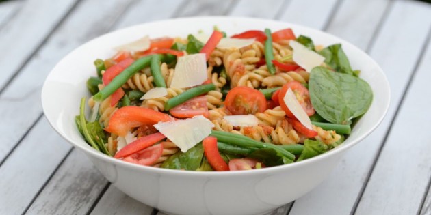 Pastasalaten er fyldt med rød pesto, basilikum, persille og en masse dejlige grøntsager.