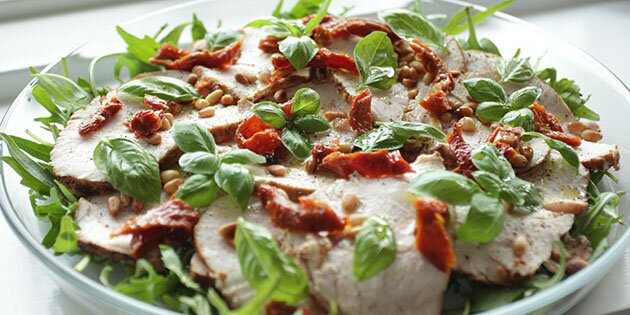 Tynde skiver af saftigt kalkunbryst toppet med soltørrede tomater, pinjekerner og basilikum