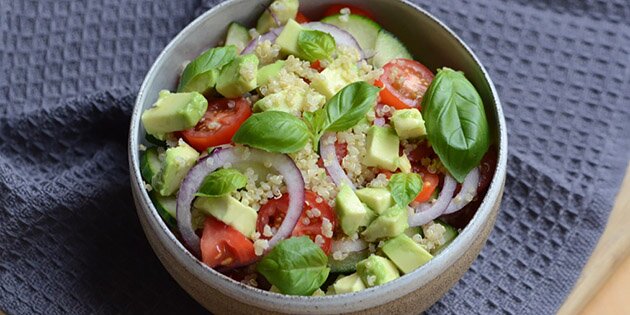 Den skønne quinoasalat kan serveres med lidt ekstra avocado, tomat og basilikum på toppen.