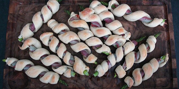 Små, finurlige asparges med bacon og brød udenom.