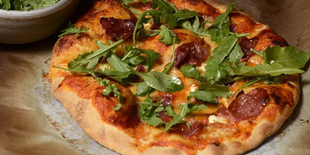 Sprød og helt fantastisk pizza med parmaskinke og frisk rucola ovenpå.