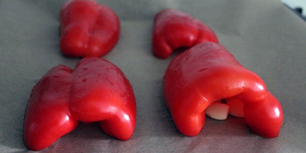 Læg peberfrugterne med skindsiden opad, så skindet bliver sort i ovnen.