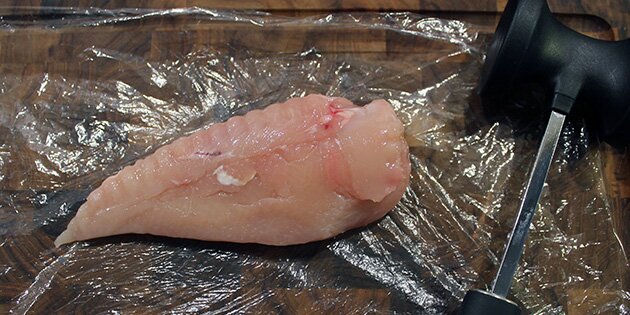 Læg kyllingen imellem to stykker film, så det ikke sprøjter.