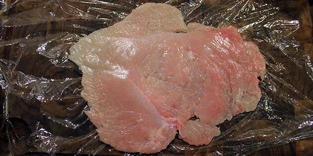 Bank kyllingen flad med en kødhammer eller kagerulle.