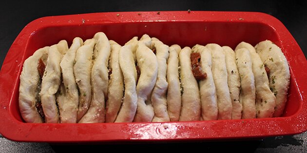 Stabl de flade boller med fyld oven på hinanden i en rugbrødsform.