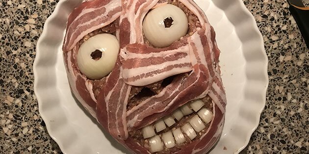 Farsbrødet pyntes med bacon og løg, så det kommer til at ligne et ansigt i forbindinger