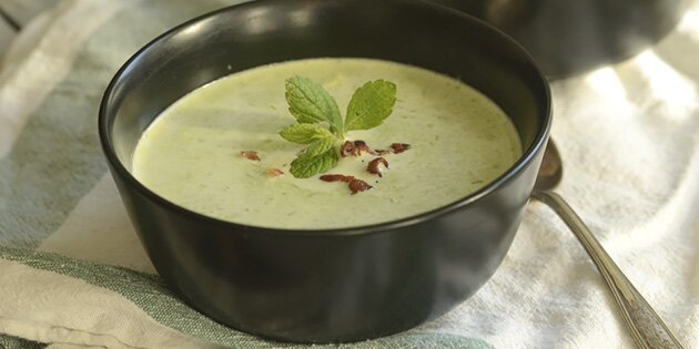 Den nemme ærtesuppe kan serveres med sprød bacon, creme fraiche og lidt friske krydderurter.