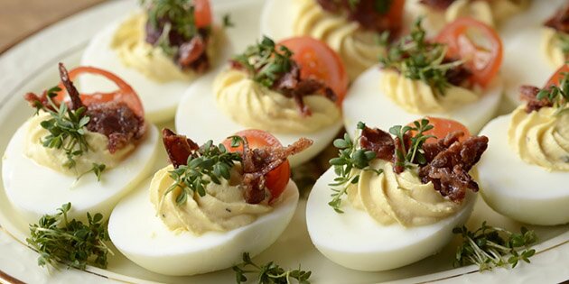 De hårdkogte æg med cremet fyld og sprød bacon på toppen.