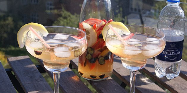 Servér velkomstdrinken i flotte glas med citronskiver på kanten.