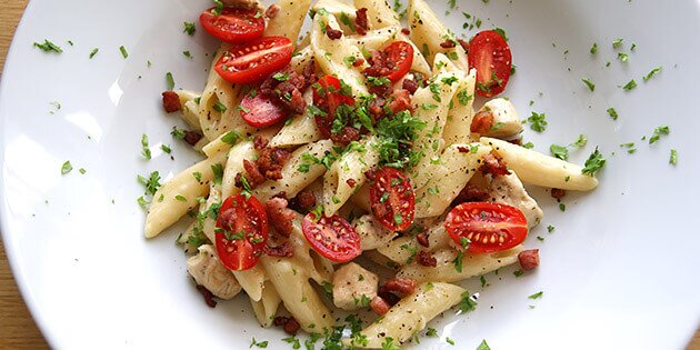 Top one pot pastaen med sprødstegt bacon, der passer super godt til den cremede sauce.