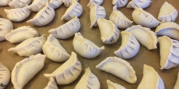 De vegetariske dumplings er foldede og klar til at blive tilberedt.