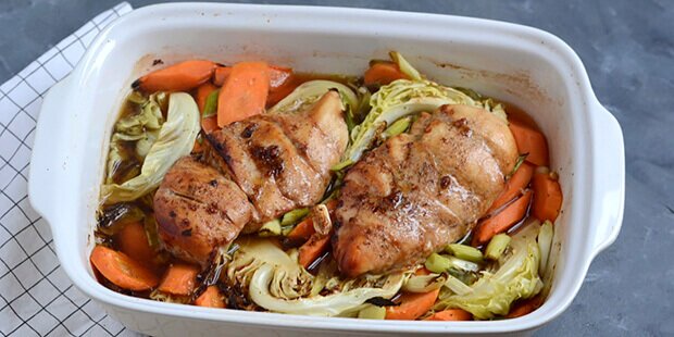 Kyllingefileterne steges saftige i ovnen på en bund af grøntsager.