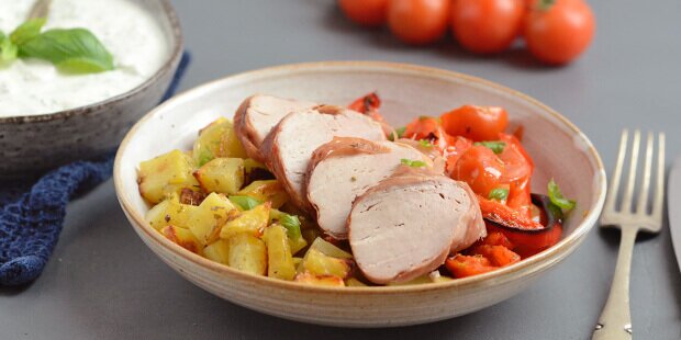 Mørbraden, de gyldne kartofler og de bagte tomater og peberfrugter serveres med en suveræn dressing.