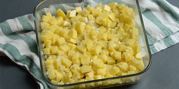 Først steges kartofler og løg for sig selv i ovnen.