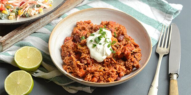 Den mexicanske gryderet er ekstra lækker toppet med creme fraiche, forårsløg og limesaft.