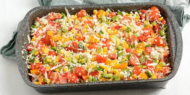 Blomkålsrisen er i godt selskab med grøntsager i form af tomater, peberfrugt og forårsløg.