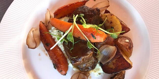 Braiseret oksebov anrettet med blomkålsmos, stegte gulerødder og kartofler samt verdens bedste sovs serveret ved siden af.