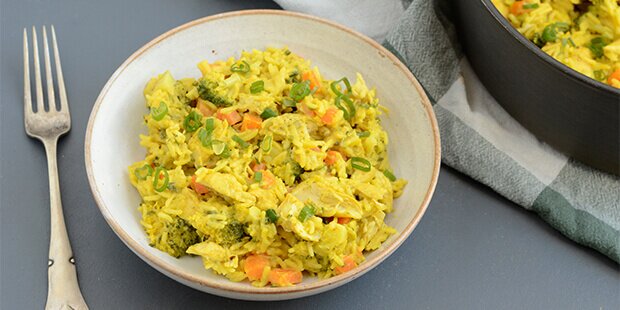 Den skønne gang kylling i karry med ris og grøntsager kan serveres med lidt frisk forårsløg på toppen.