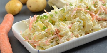 Den lækre kartoffelsalat er fyldt med spidskål, forårsløg, creme fraiche og gulerødder