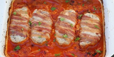 Lækre koteletter pakket ind i bacon og tilberedt i et fad med fløde-tomatsovs med paprika.
