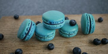 Små og lækre blå macarons fyldt med blåbær og hvid chokolade