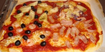 Pizza med forskellige ingredienser på fire dele.