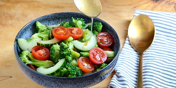 Oliedressingen hældes over broccolisalaten