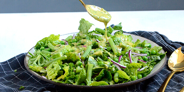 Server enten dressingen ved siden af eller hæld den over inden servering