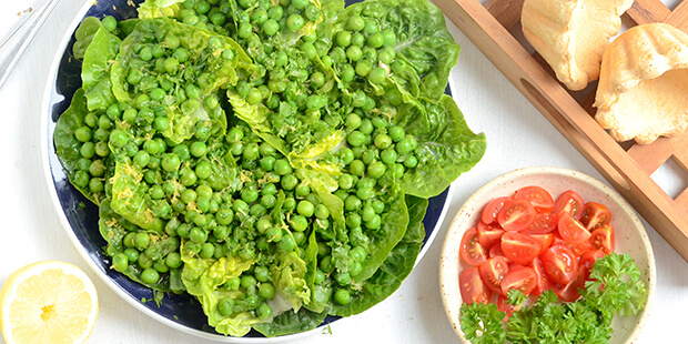 Dejlige grønne ærter vendes i smør og citron og hældes over hjertesalaten.