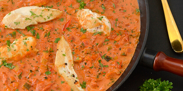 De lækre brunede kyllingefileter vendes i flødetomatsovsen til slut og varmes igennem.