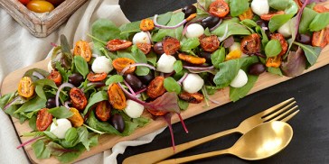 Mozzarella, bagte tomater og frisk grønt gør salaten super velegnet at servere til tapas