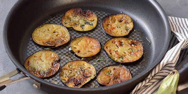 Skiverne af aubergine er blevet stegt lækkert gyldne på panden.