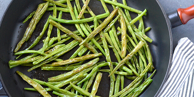 De grønne bønne vendes i smør og får dejlig smag af hvidløg.