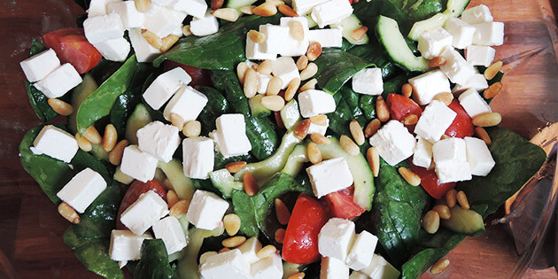 Spinatsalaten set fra oven med masser af feta på toppen.