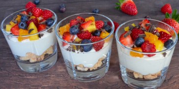 Hurtig dessert med makroner, creme og frugt anrettet i glas