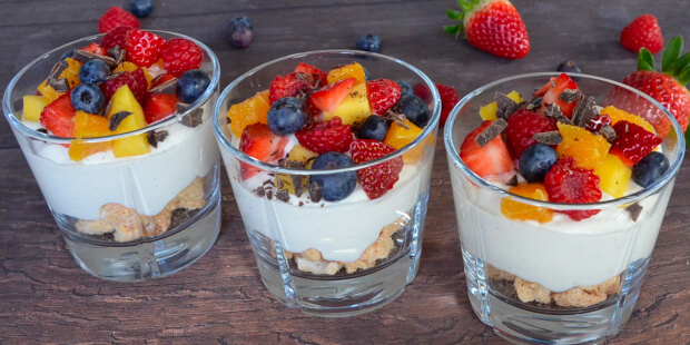 Hurtig dessert med makroner, creme og frugt anrettet i glas
