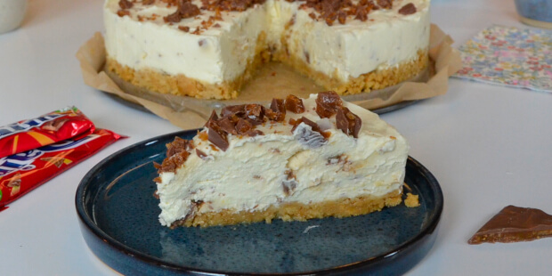 Et stykke af kagen med kiks i bunden og cremet fyld med hakket Daim bar