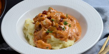 Gryderet med kylling og champignon samt bacon og persille på toppen