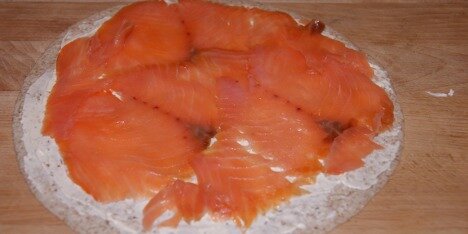 Ovenpå flødeosten fordeles laksen.